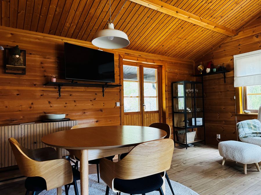 Björnhus – Essbereich mit rundem Tisch und TV