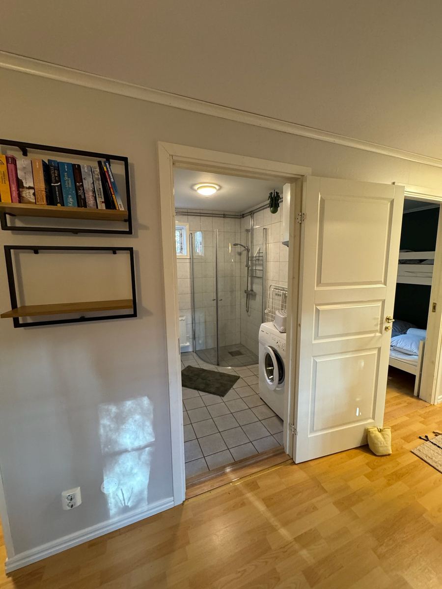 Blåbärhus – Badezimmer mit Dusche und Waschmaschine